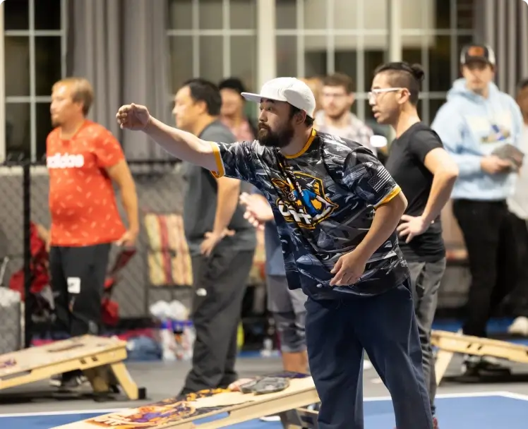 a man in a white hat and black shirt throwing a skateboard
