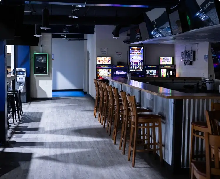 a bar with chairs and a counter with video games