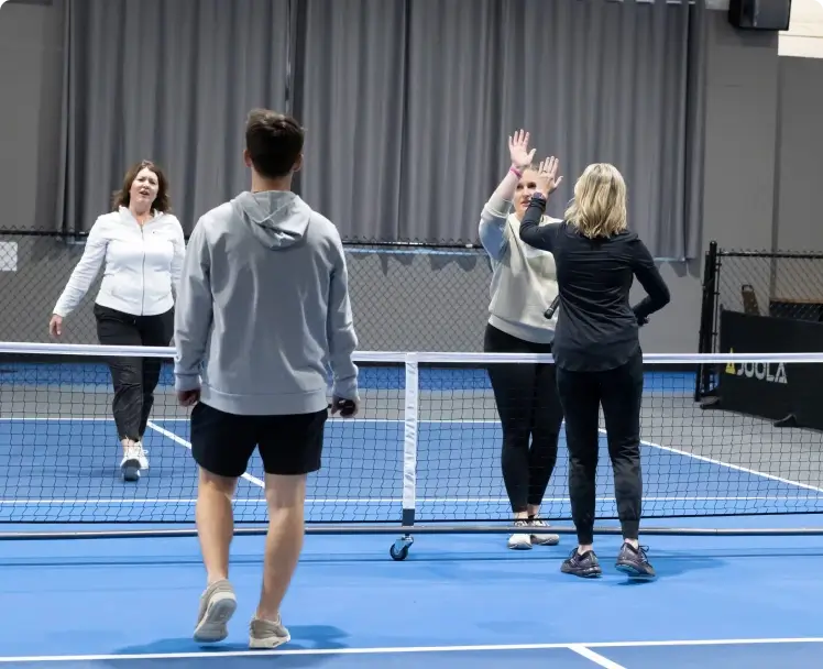 a group of people on a pickleball court