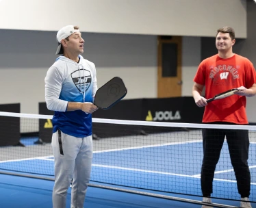 a couple of men holding pickleball rackets