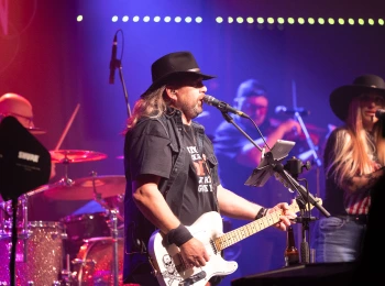 a man playing guitar and singing on stage