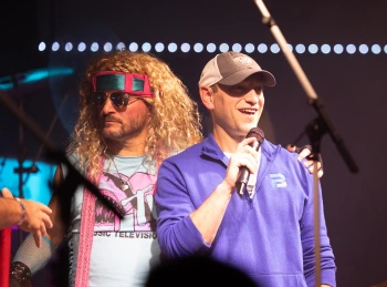 a man with a microphone and a man with a wig