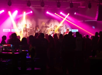 a group of people on a stage with purple lights